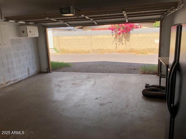 garage featuring a garage door opener and freestanding refrigerator