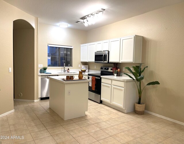 kitchen with white cabinetry, light tile patterned floors, a kitchen island, pendant lighting, and stainless steel appliances