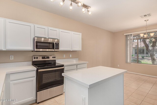 kitchen featuring sink, light tile patterned floors, appliances with stainless steel finishes, a kitchen island, and white cabinets