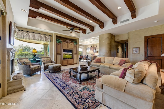 living area featuring beam ceiling, visible vents, and a wealth of natural light