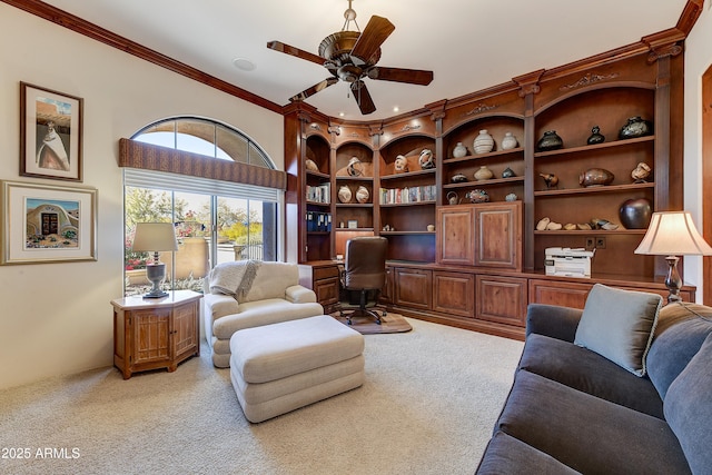 interior space featuring light carpet, a ceiling fan, crown molding, and built in study area