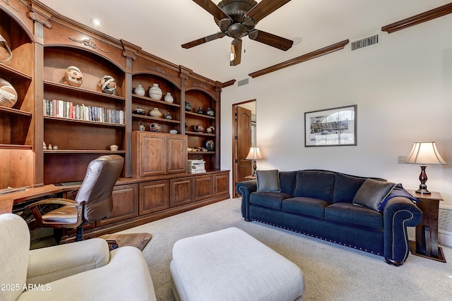 carpeted living room featuring ornamental molding, visible vents, ceiling fan, and built in study area