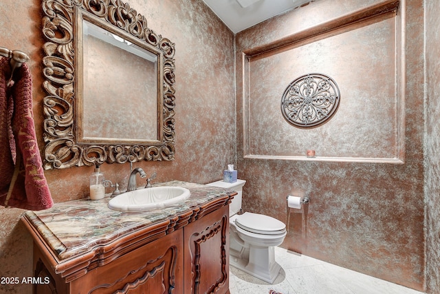 half bathroom with vanity, toilet, and tile patterned floors