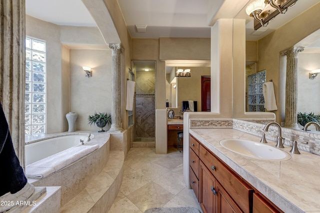 bathroom with a garden tub, a shower stall, vanity, and ornate columns