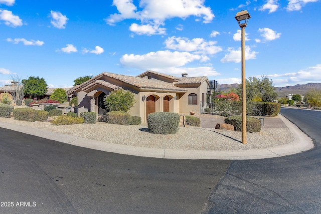 mediterranean / spanish home with stucco siding and a tiled roof