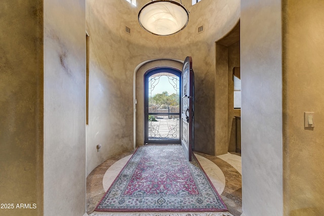 entrance foyer featuring a towering ceiling and arched walkways