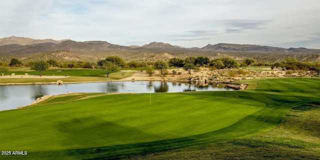 surrounding community featuring view of golf course, a lawn, and a water and mountain view