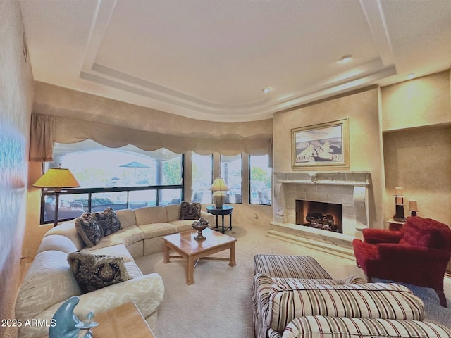 living room featuring carpet floors, a tray ceiling, and a fireplace