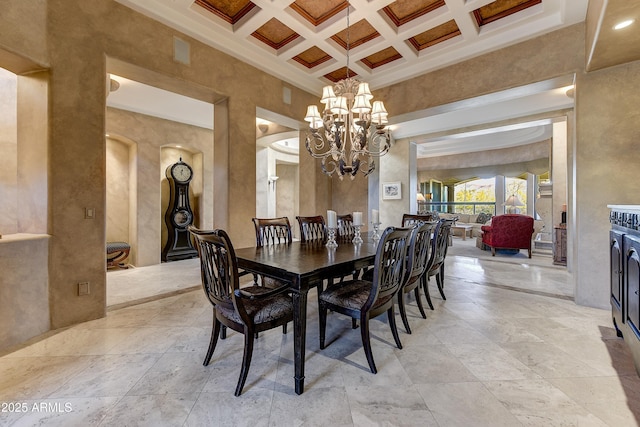 dining room featuring a towering ceiling, a chandelier, coffered ceiling, and beamed ceiling