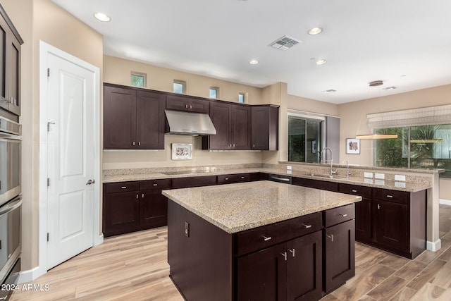 kitchen featuring light hardwood / wood-style floors, a center island, dark brown cabinetry, and sink