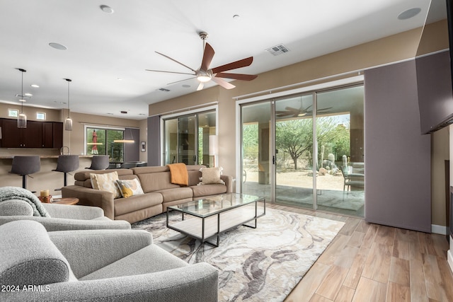 living room with ceiling fan and light hardwood / wood-style flooring