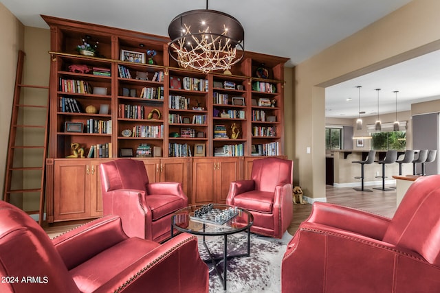 living area featuring light hardwood / wood-style floors and an inviting chandelier