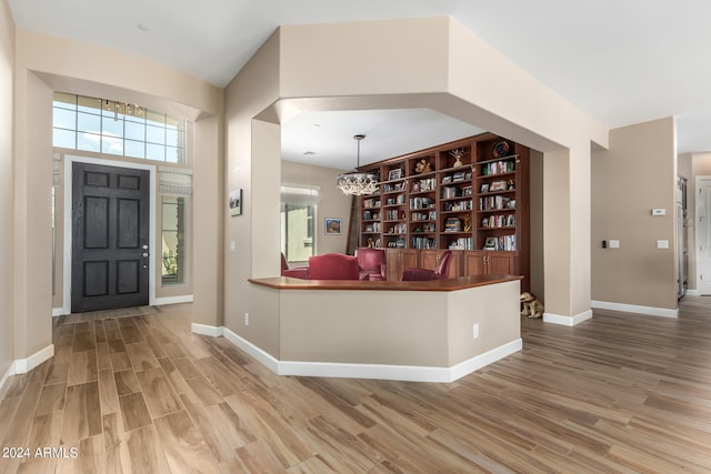 foyer featuring wood-type flooring and a chandelier