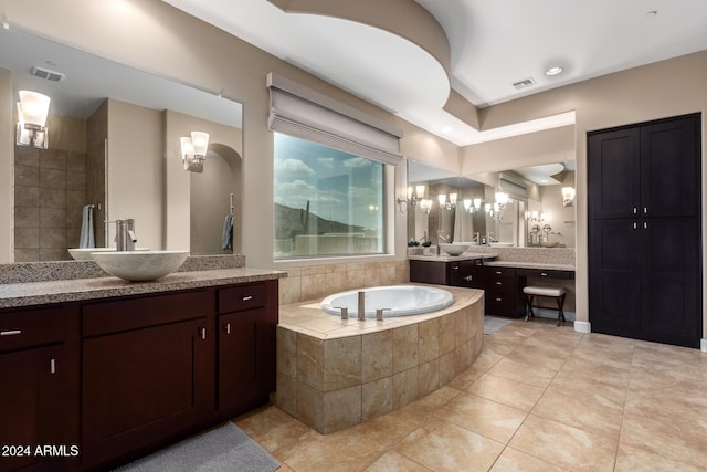 bathroom featuring tile patterned flooring, vanity, and a relaxing tiled tub