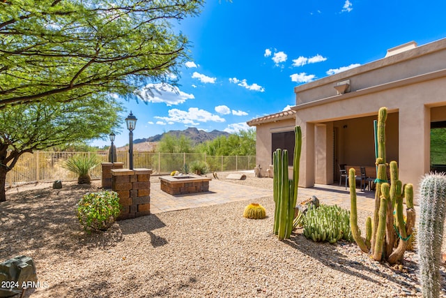 view of yard featuring a patio, a mountain view, and a fire pit