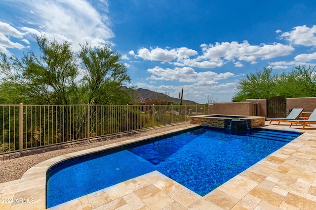 view of swimming pool featuring a patio, a mountain view, and an in ground hot tub