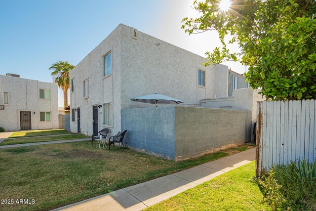 7506 N 47th Dr, Glendale, AZ 85301 - view of home's exterior with a yard, stucco siding, and fence