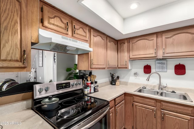 7506 N 47th Dr, Glendale, AZ 85301 - kitchen featuring light countertops, under cabinet range hood, brown cabinetry, stainless steel electric stove, and a sink