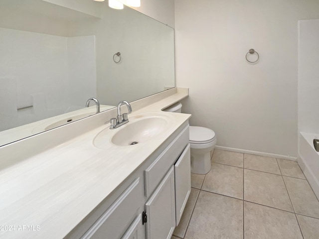 bathroom featuring tile patterned flooring, vanity, a bath, and toilet