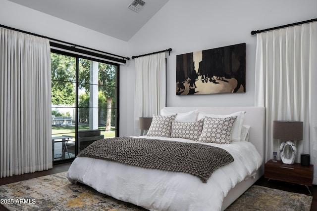 bedroom featuring access to exterior, lofted ceiling, and dark hardwood / wood-style flooring