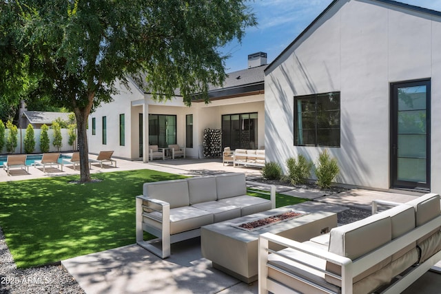 view of patio featuring a swimming pool and an outdoor living space with a fire pit