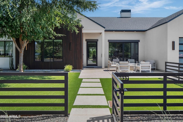 view of exterior entry with a yard and an outdoor hangout area