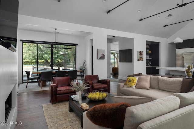 living room with hardwood / wood-style floors, a healthy amount of sunlight, and vaulted ceiling