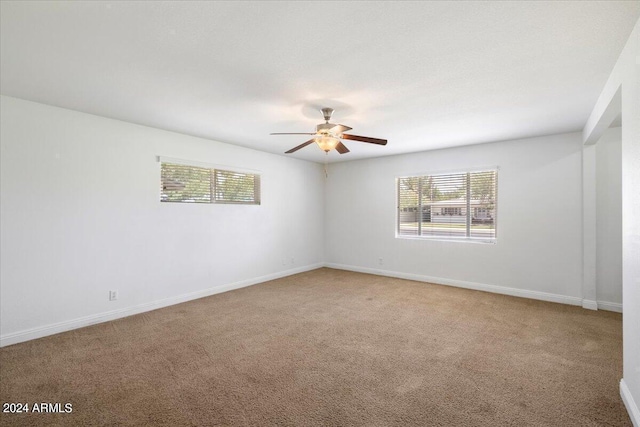 spare room featuring ceiling fan and light carpet