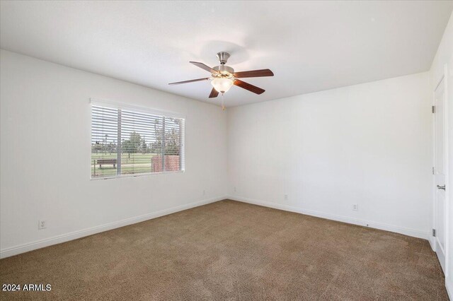 carpeted spare room with ceiling fan