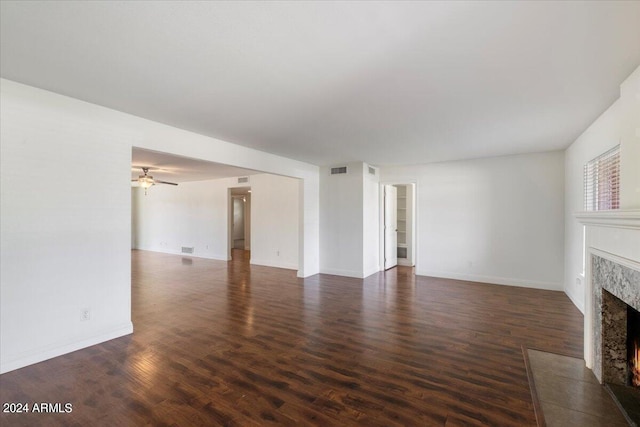 unfurnished living room with ceiling fan, a fireplace, and dark hardwood / wood-style floors