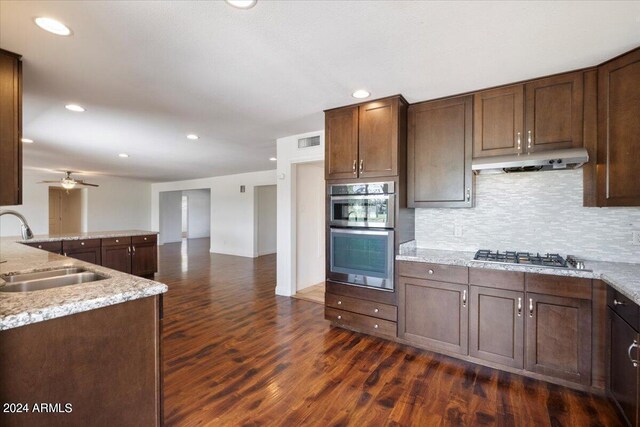 kitchen featuring sink, dark wood-type flooring, tasteful backsplash, ceiling fan, and stainless steel appliances