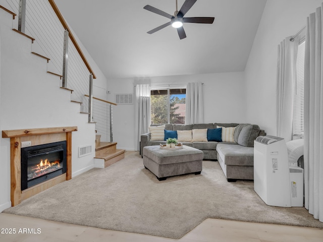 living area featuring stairway, ceiling fan, vaulted ceiling, and visible vents