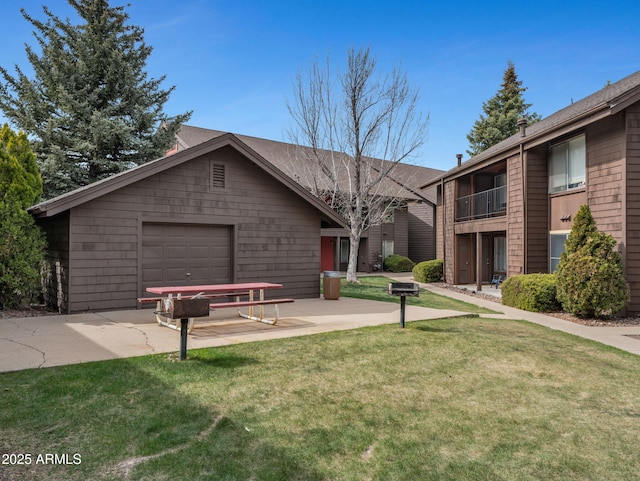 view of front of house featuring a garage, a front yard, and concrete driveway