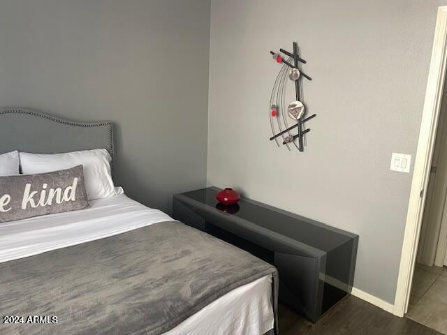 bedroom featuring dark wood-style floors and baseboards