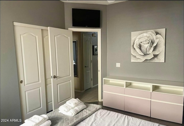 bedroom with light tile patterned floors and a closet