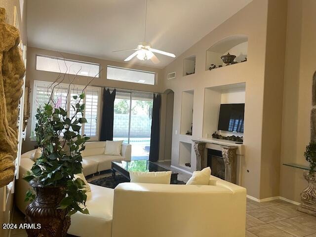 tiled living room featuring ceiling fan and vaulted ceiling