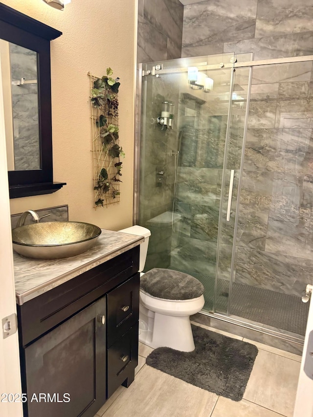 bathroom with toilet, a stall shower, tile patterned flooring, and vanity