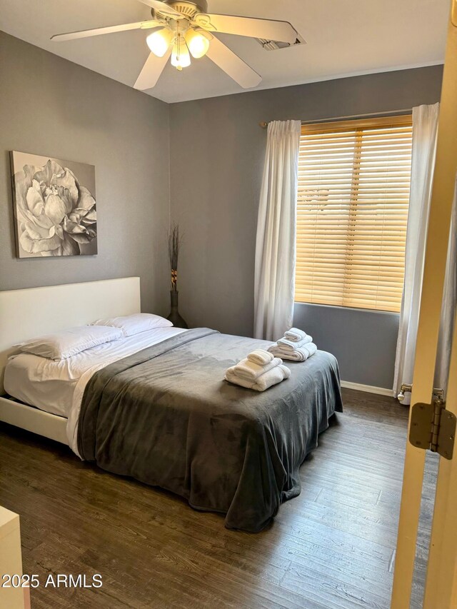 bedroom with dark wood-style floors and a ceiling fan