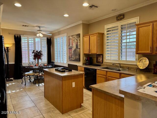 kitchen with plenty of natural light, visible vents, a kitchen island, black appliances, and a sink