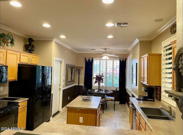 kitchen featuring a center island, light countertops, visible vents, a sink, and black appliances