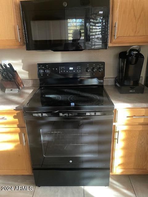 kitchen featuring black appliances and light tile patterned floors