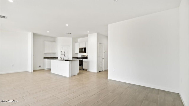 653 W Freedom St, Florence, AZ 85132 - kitchen featuring appliances with stainless steel finishes, open floor plan, recessed lighting, an island with sink, and dark countertops