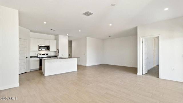 653 W Freedom St, Florence, AZ 85132 - kitchen with stainless steel appliances, open floor plan, white cabinets, an island with sink, and recessed lighting