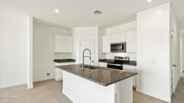 653 W Freedom St, Florence, AZ 85132 - kitchen featuring stainless steel microwave, electric range oven, a kitchen island with sink, white cabinetry, and recessed lighting