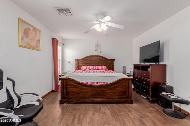 bedroom featuring wood finished floors, a ceiling fan, and baseboards