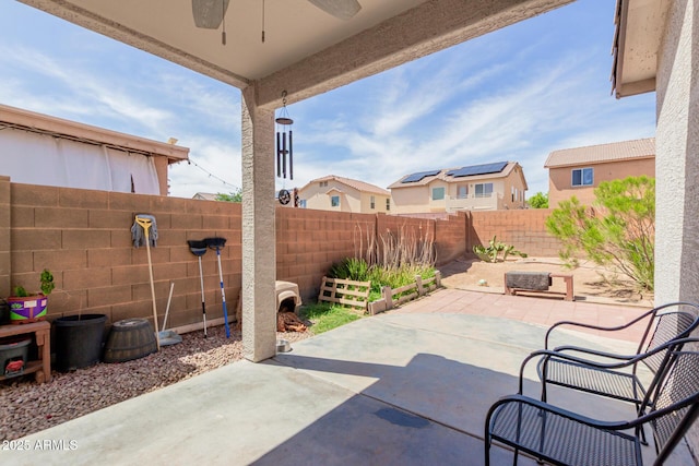 fenced backyard featuring ceiling fan, a patio, and a residential view