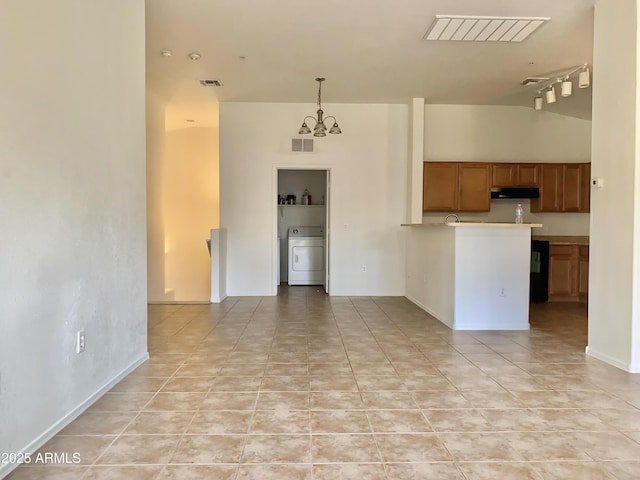 2402 E 5th St Unit 1472, Tempe, AZ 85288 - kitchen with washer / dryer, extractor fan, brown cabinets, a chandelier, and light tile patterned floors
