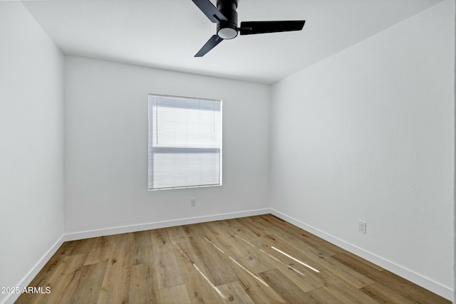 spare room featuring light wood-style flooring, baseboards, and a ceiling fan