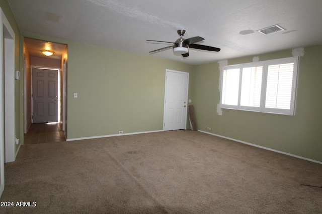 carpeted empty room featuring a textured ceiling and ceiling fan