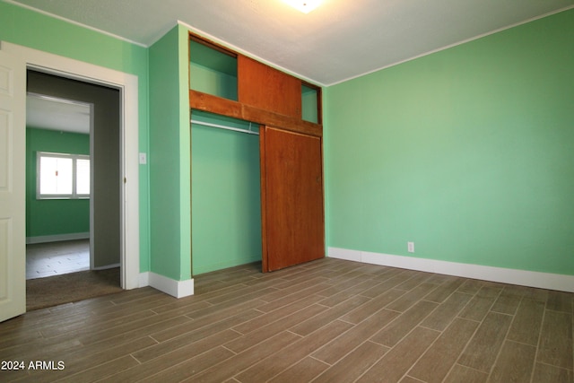 unfurnished bedroom featuring dark wood-type flooring and a closet